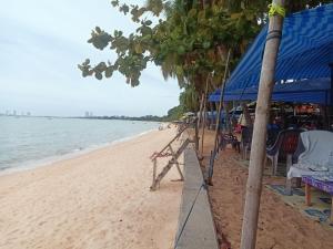 a beach with a blue tent and chairs and the ocean at คอปเตอร์ Resort in Ban Khlot