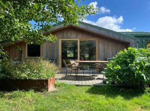 a patio with a table and chairs in front of a building at Wonderful Family House At The West Coast in Løkken