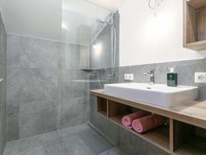 a bathroom with a sink and a glass shower at Heualm in Hopfgarten im Brixental +32 photos