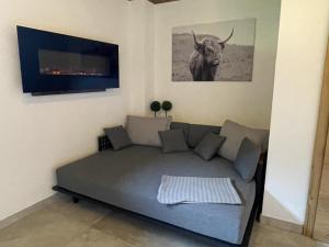 a living room with a couch and a picture of a bull at Heualm in Hopfgarten im Brixental