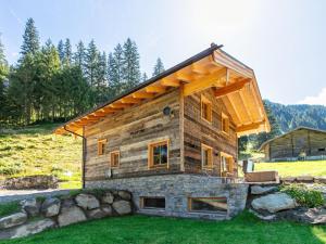 a log house on top of a grass field at Heualm in Hopfgarten im Brixental