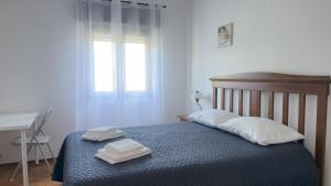 a bedroom with a bed with two towels on it at Casa Vale de Água em Santarém in Santarém +40 photos