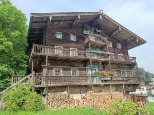 a large wooden house with a balcony and flowers at Alte Grafenmühle in Hopfgarten im Brixental