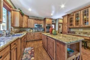 a kitchen with wooden cabinets and granite counter tops at Lv12: luxury villa walk to the Beach in Glenbrook