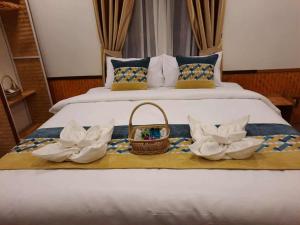 a bed with a basket and flowers on it at Pai Pavilion in Pai