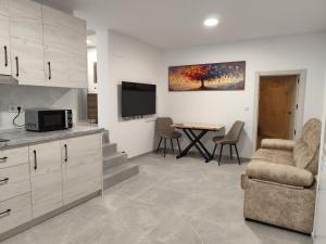 a living room with a couch and a table with a tv at Raíces de Alcalá in Alcalá del Júcar