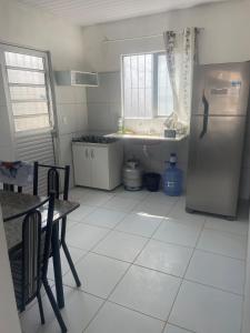 a kitchen with a refrigerator and a table and chairs at Casa aconchegante in Garanhuns