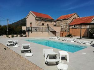a swimming pool with chaise lounge chairs and a swimming pool at House Serenity with Pool in Vrgorac