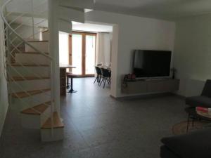 a living room with a staircase and a television at House Serenity with Pool in Vrgorac