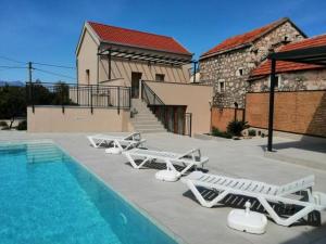a group of lounge chairs next to a swimming pool at House Serenity with Pool in Vrgorac