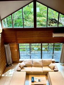 een woonkamer met een bank en een groot raam bij rinne 2nd living Nasu Creek in Nasu