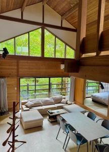 een woonkamer met een bank, tafels en ramen bij rinne 2nd living Nasu Creek in Nasu