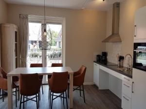 アルメンにあるCozy villa in the middle of the Achterhoekのテーブルと椅子と窓のあるキッチン