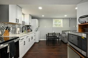 a kitchen with white cabinets and a table and chairs at 2BR Home KC Stadiums Great Location I-70 in Blue Springs