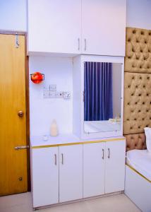 a bedroom with white cabinets and a mirror at 4BR Apt I 2 King SIZE BED I 2 Queen Size bed I Dhanmondi & Crescent Lake, Dhaka in Dhaka