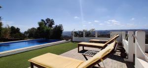 a patio with two chairs and a swimming pool at Varandas do Vale Furnazinhas in Castro Marim