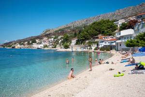 a group of people playing in the water on a beach at Apartments with parking space Sumpetar, Omis - 951 in Sumpetar