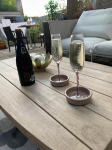 a table with two wine glasses and a bottle of wine at Peaceful and Stylish Garden Flat Close to Transport and City Centre in Glasgow +14 photos