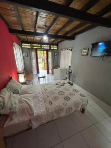 ein Schlafzimmer mit einem großen Bett und einem Fernseher in der Unterkunft La casa de Jessi in Máncora