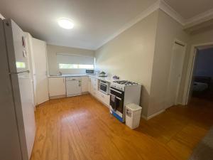 an empty kitchen with a stove and a refrigerator at Cloncurry Caravan Park Oasis in Cloncurry