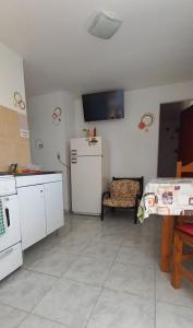 eine Küche mit Kühlschrank, Tisch und Fernseher in der Unterkunft Jeleta 1 in Puerto Madryn