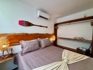 a bedroom with a bed with a wooden headboard at Villa Naluri - Casa Auati - Apart 2 Quartos -Vista Mar in Japaratinga +49 photos