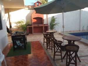 a patio with a table and chairs and an umbrella at Casa en playas in Playas +6 photos