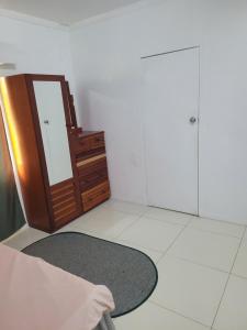 a white room with a mirror and a rug at Shalom Home Stay in Nadi International Airport +3 photos