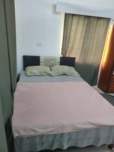 a bed sitting in a room with a window at Shalom Home Stay in Nadi International Airport