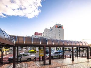 a bus stop in a city with cars parked at APA Hotel Yamagata Tsuruoka Ekimae in Tsuruoka