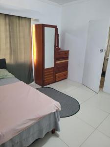 a bedroom with a bed and a dresser and a mirror at Shalom Home Stay in Nadi International Airport