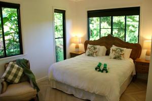 a bedroom with a bed with two shoes on it at Exclusive Isolated Getaway Mowbray Port Douglas in Mowbray +28 photos