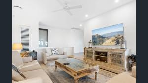 a living room with a large painting above a fireplace at Exclusive Isolated Getaway Mowbray Port Douglas in Mowbray