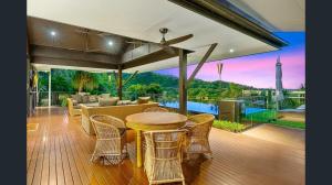 a living room with a table and chairs on a deck at Exclusive Isolated Getaway Mowbray Port Douglas in Mowbray