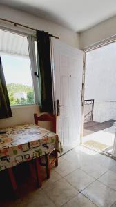 Zimmer mit einer Tür, einem Bett und einem Fenster in der Unterkunft Jeleta 1 in Puerto Madryn