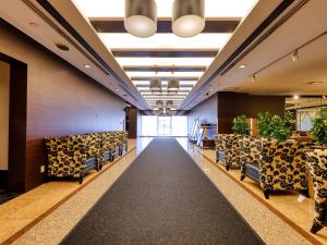 an empty lobby with chairs and plants at APA Hotel Yamagata Tsuruoka Ekimae in Tsuruoka