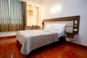 um quarto de hotel com uma cama grande e uma janela em Hotel INTI TUMI em Lima