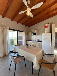 een keuken met een tafel en een plafondventilator bij Refugio de las Nubes in Las Rabonas