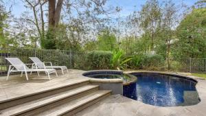 a patio with two chairs and a swimming pool at 2 Marma Retreat - Peaceful Surrounds with Heated Pool & Spa in Red Hill