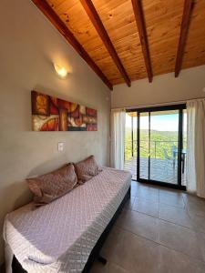 een slaapkamer met een bed in een kamer met een balkon bij Refugio de las Nubes in Las Rabonas