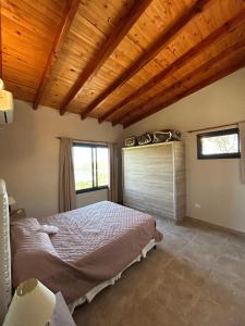 een slaapkamer met een bed en een houten plafond bij Refugio de las Nubes in Las Rabonas +15 foto's