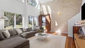 a living room with a couch and a table at 2 Marma Retreat - Peaceful Surrounds with Heated Pool & Spa in Red Hill