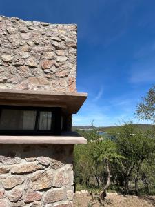 een stenen huis met een raam aan de zijkant bij Refugio de las Nubes in Las Rabonas