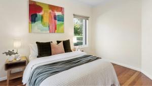 a white bedroom with a bed and a window at 2 Marma Retreat - Peaceful Surrounds with Heated Pool & Spa in Red Hill +12 photos