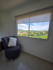 a room with a chair and a large window at Apartamento familiar, tranquilo in Curití