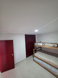 a room with two bunk beds and a red door at Apartamento familiar, tranquilo in Curití