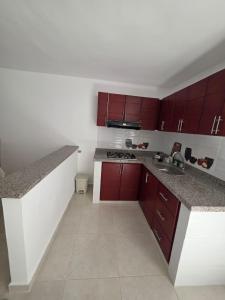 a kitchen with red cabinets and a counter top at Apartamento familiar, tranquilo in Curití