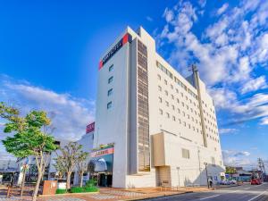 a tall white building with a sign on it at APA Hotel Yamagata Tsuruoka Ekimae in Tsuruoka +76 photos