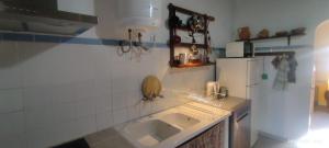 a kitchen with a sink and a refrigerator at Solar Verbena in Vaiamonte +63 photos