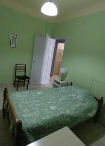 a bedroom with a bed and a chair in it at Casa del Arbol in San Fernando del Valle de Catamarca